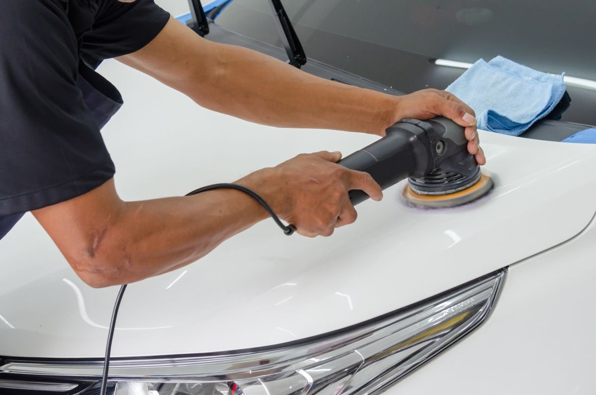 Técnico aplicando micropulida con pulidora orbital sobre la pintura de un auto